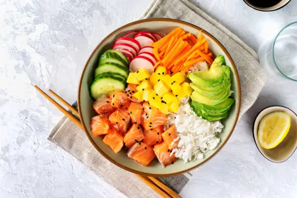 Close up of salmon poke with avocado, seaweed, pickled carrots and cucumber