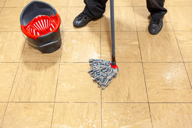 istock Cleaner with a mop and bucket cleaning a tiled floor 1203557801