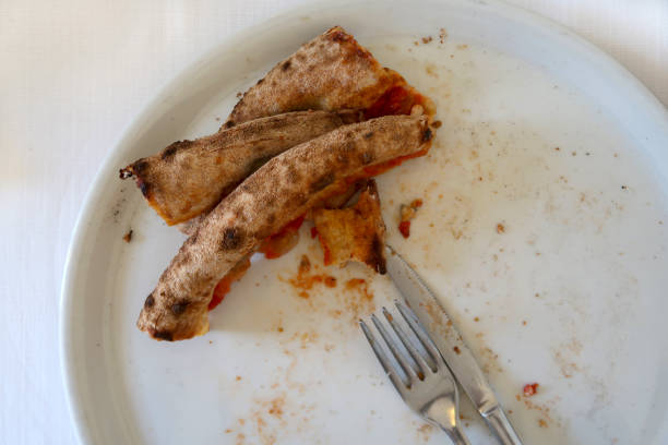 istock Remains of pizza which has been eaten, only burned edges left 1203559968