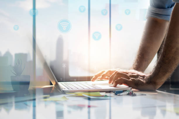 istock business man use laptop with WiFi and  internet icon 1203560283