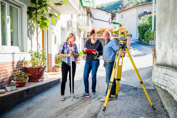 Team of Surveyors Planning and Discussing on Village Street - Stock Photo Team of Surveyors Planning and Discussing on Village Street. yard measurement stock pictures, royalty-free photos & images