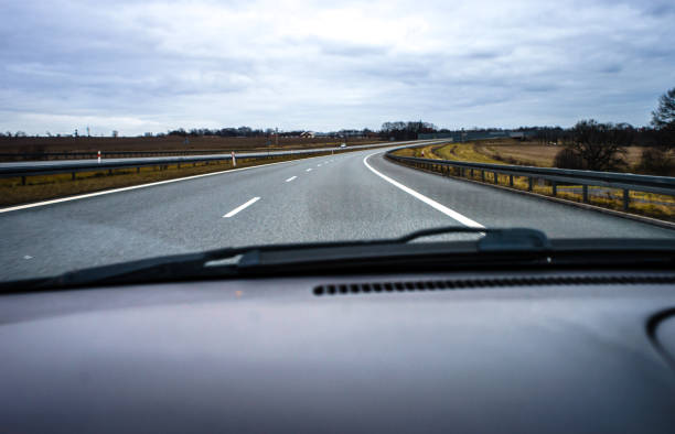 istock A two-lane highway seen from a moving car through the windshield. 1203561797