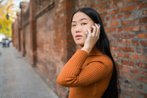 istock Asian woman talking on the phone. 1203563664