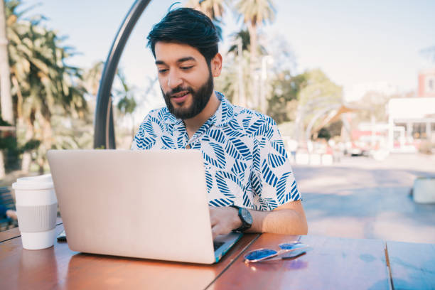 istock Young man using his laptop in a coffee shop. 1203563766