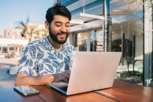 istock Young man using his laptop in a coffee shop. 1203563770