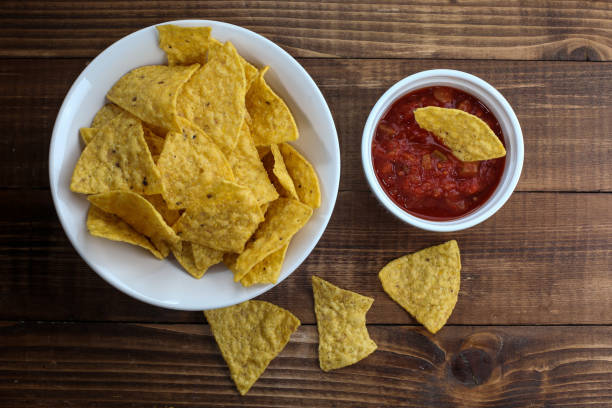 istock Tortilla chips inside a bowl with salsa on rustic wooden table 1203566338