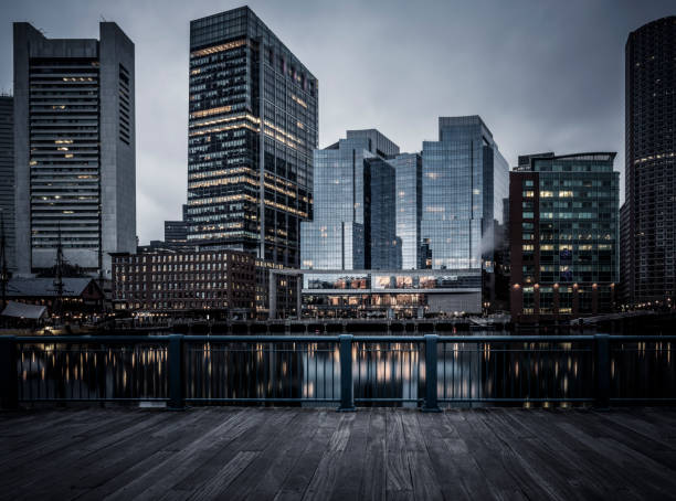 Futuristic style photo of Boston Financial District from Harborwalk View of downtown Boston and the financial district from across Boston Harbor - desaturated long exposure photo at dusk boston skyline night skyscraper stock pictures, royalty-free photos & images