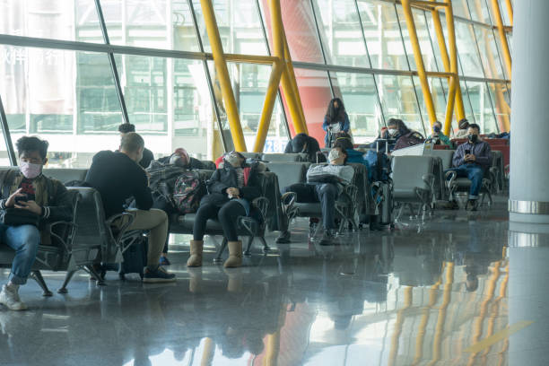 Beijing, China, January 31, 2010:  Beijing Capital International Airport during the outbreak of Corona virus. The virus has rapidly spread and became a global health emergency. Everyone wears mask including this group of exhausted passengers waiting for their flights.