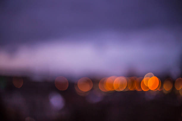 Lighting the road in the night city. Blurred abstract photography. Purple hue of the sky.