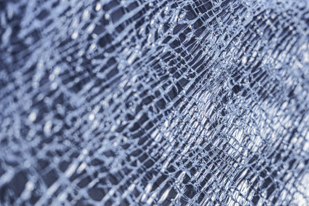 istock broken glass background. a glass window cracked with cobwebs. abstraction 1203577354