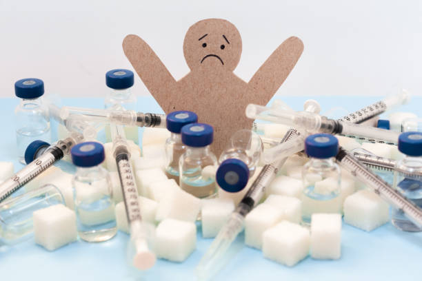 dépendance au sucre, résistance à l’insuline, alimentation malsaine, figure d’un homme en carton entouré de cubes de sucre raffinés, seringue pour la vaccination et bouteilles d’insuline sur fond blanc, concept médical de protection du diabète - insulin sugar syringe bottle photos et images de collection