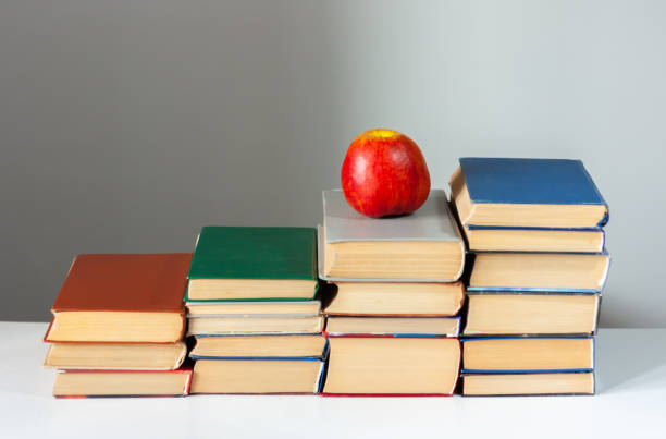 istock stack of hardback books on white table with red apple. Books stacking. Back to school concept. Copy Space. Education learning background 1203580787