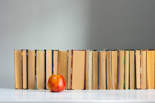 istock stack of hardback books on white table with red apple. Books stacking. Back to school concept. Copy Space. Education learning background 1203580840