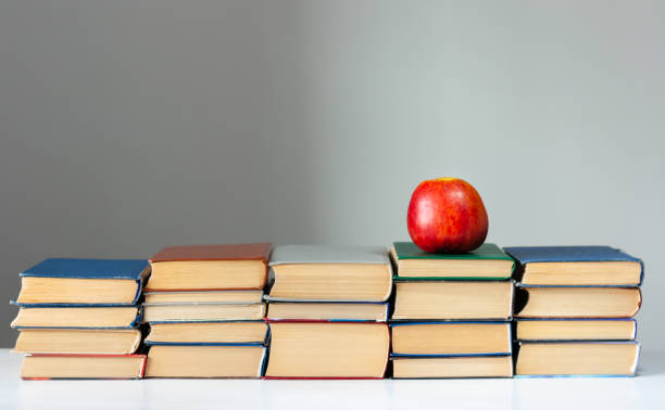istock stack of hardback books on white table with red apple. Books stacking. Back to school concept. Copy Space. Education learning background 1203580841