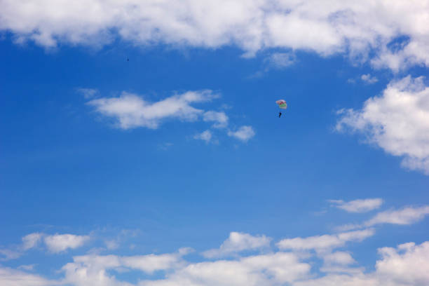 paragliders in flight in the sky with clouds