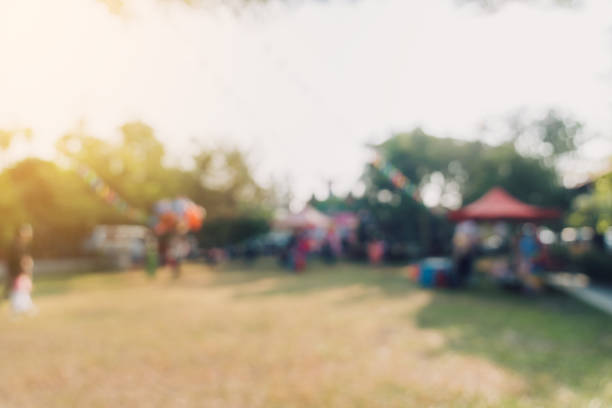 ボケの背景を持つ都市公園の庭の祭りで抽象的なぼかしの人々と日光。 - city street street walking tree ストックフォトと画像