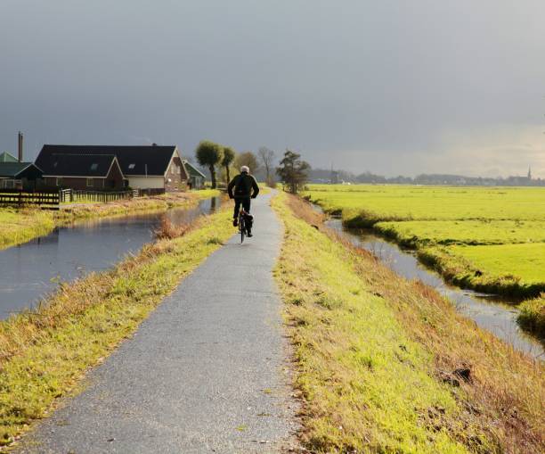 田舎のサイクルパス上のサイクリスト - footpath single lane road road farm ストックフォトと画像