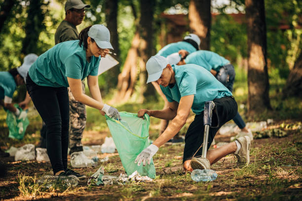 istock Volunteers cleaning garbage together in park 1203586569
