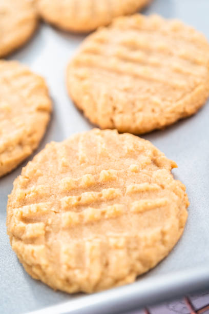 istock Freshly baked peanut butter cookies on a baking sheet. 1203586679