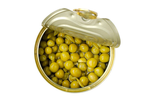 istock Open tin can with green peas on a white background. View from above. Green peas in a jar isolated on a white background. Canned green peas in a jar. 1203587811