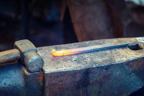 istock Blacksmith working metal with hammer on the anvil 1203589590