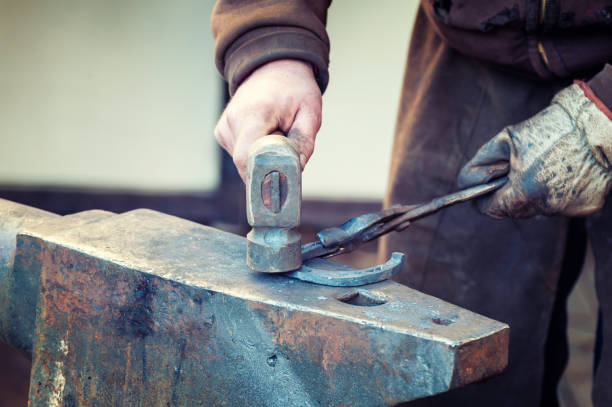 istock Blacksmith working metal with hammer on the anvil 1203589595