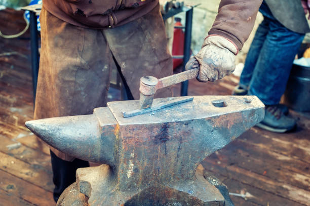 istock Blacksmith working metal with hammer on the anvil 1203589601