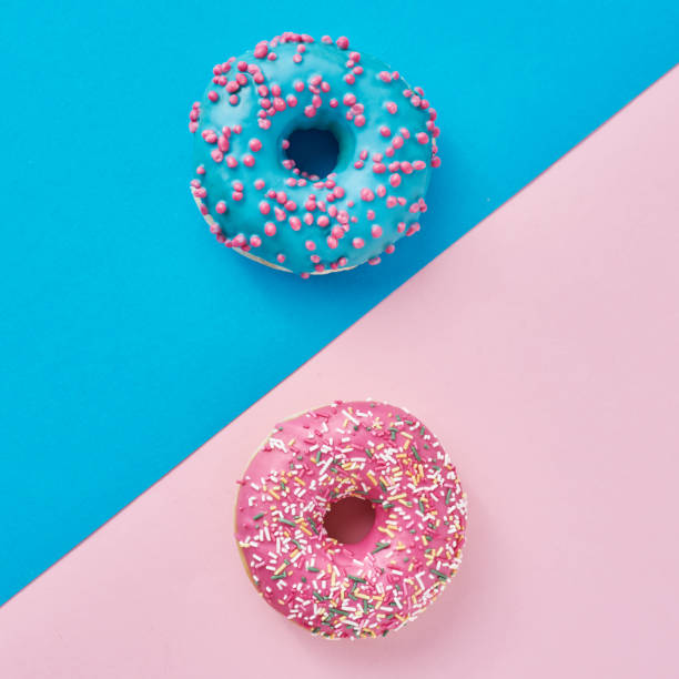 istock Two donuts on a pastel pink and blue background. Minimalism creative food composition. Flat lay style 1203589837