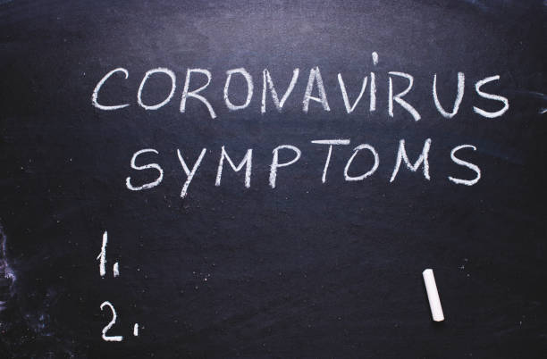 istock Inscription coronavirus, symptoms on chalk board. 1203591128