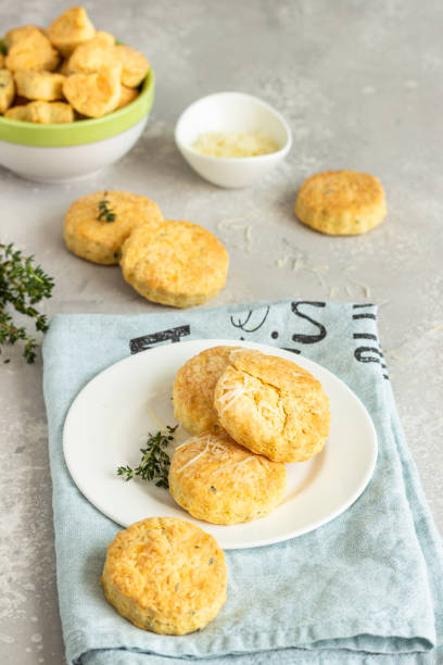 istock Savory scones or cookies with cheese and thyme on a white ceramic plate. Light grey concrete background. 1203593749
