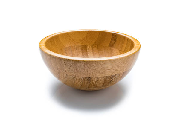 Single empty wooden bowl isolated on reflective white background. Useful copy space available for text and/or logo. Predominant colors are brown and white. High resolution 42Mp studio digital capture taken with SONY A7rII and Zeiss Batis 40mm F2.0 CF lens