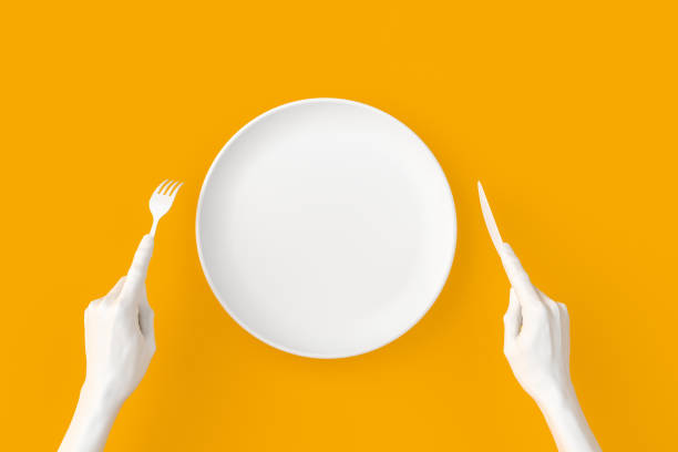 istock Abstract food restaurant concept banner. Isolated white empty plate, hands holding fork and knife, top view 3d rendering. 1203594249
