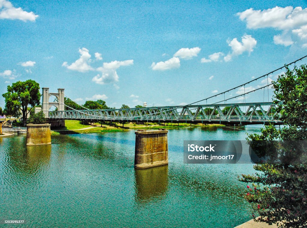 Waco Suspension Bridge Brazos River This suspension bridge crosses the Brazos river in Waco Texas near the Texas Ranger Museum built in 1870. Waco Stock Photo