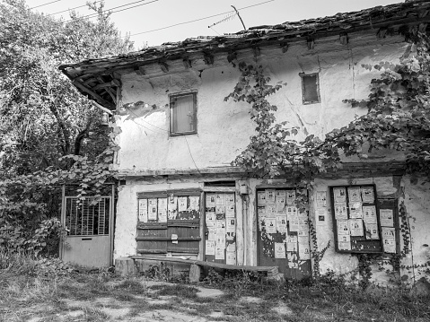 Oreshak, Bulgaria - September 04, 2011: Old house with obituary notes at Baba Stana Neighborhood, Oreshak, Bulgaria, black and white photography