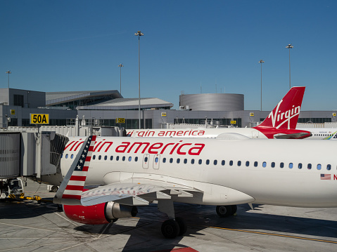 Denver, CO July 17, 2018: Virgin America now Alaska Airlines planes on runway connected to terminal by a passenger boarding bridge