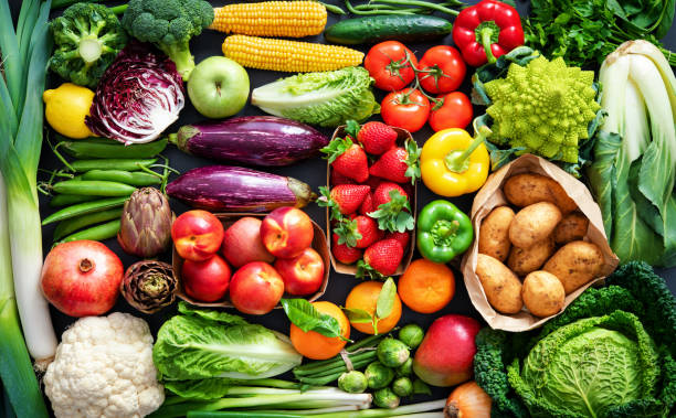 food background with assortment of fresh organic fruits and vegetables - fruit imagens e fotografias de stock