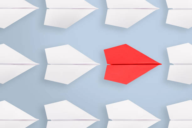 istock Change concepts with red paper airplane leading among white 1203601867