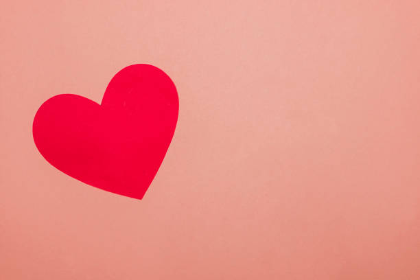 istock one red craft paper heart on pink background with copy space 1203601937