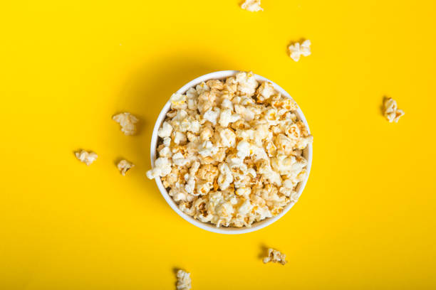 istock Popcorn viewed from above on yellow background. Flat lay  bowl. Top view 1203602084