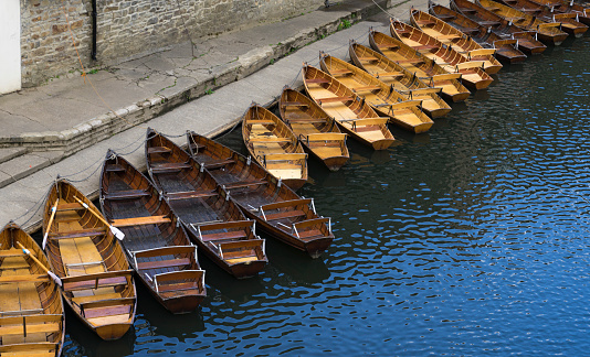 Small boats moored at the edge of the Wear River as it passes through the city of Durham.