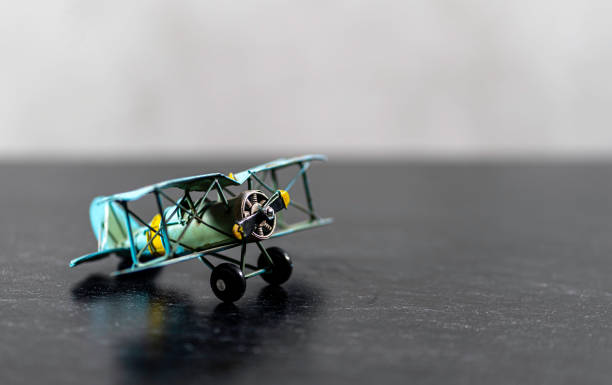 istock Small Biplane model on grey background green yellow 1203606829
