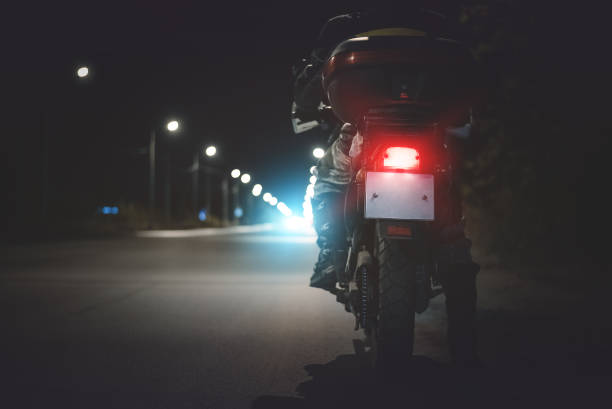 motociclista. - street light dark street men - fotografias e filmes do acervo