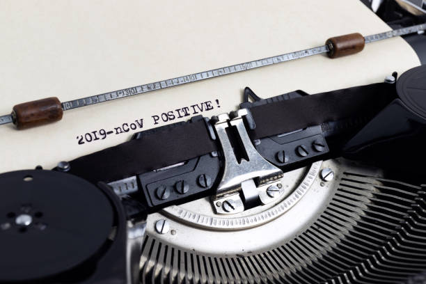 istock Heading 2019-cCoV Positive written with typewriter on yellowish paper 1203607994