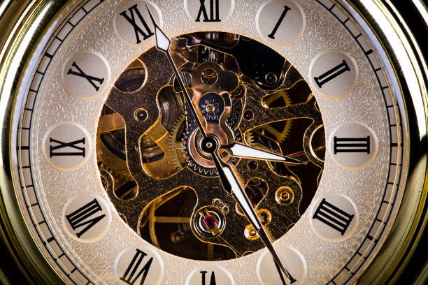 Antique clock on the background of vintage books. Mechanical clockwork on a chain. stock photo