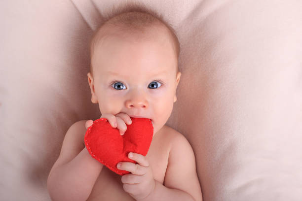 istock Cute baby with red toy heart. 1203609166