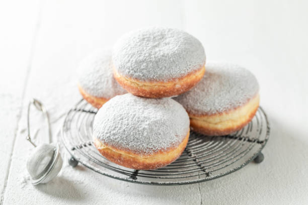 istock Sweet donuts with powdered sugar on white table 1203610472