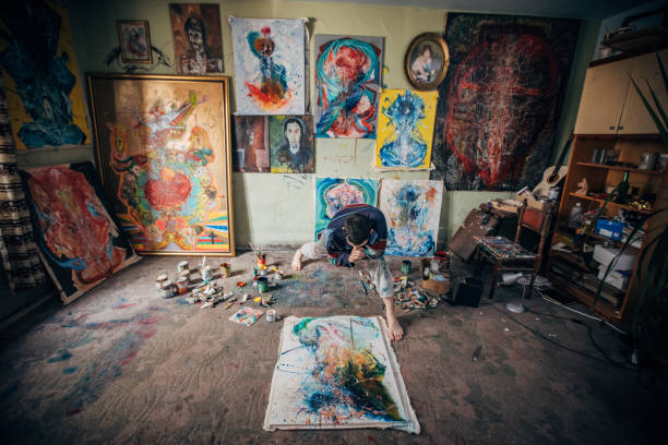 istock Artist working on painting in studio 1203611060