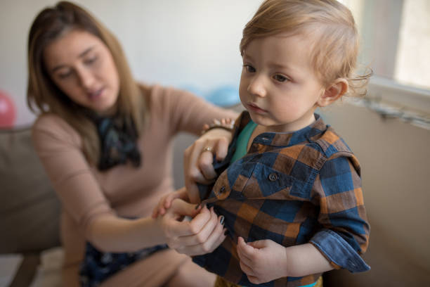 istock pregnant woman is dressing up her son 1203611335