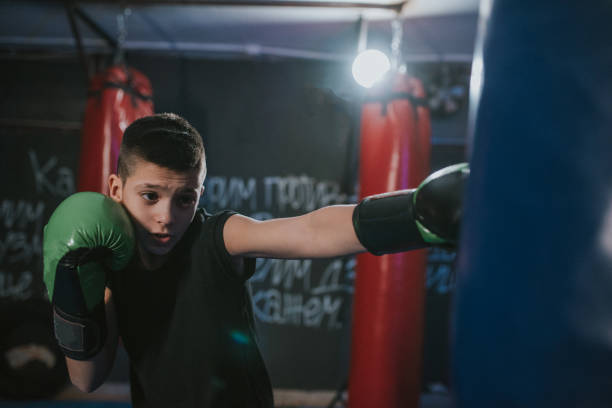 istock Young kickbox fighter exercises blows on the pear 1203612372