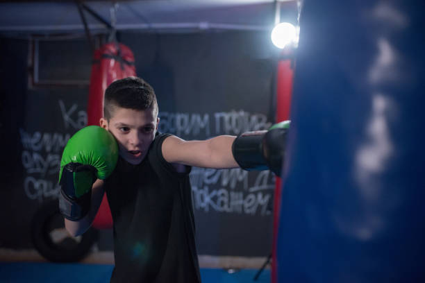 istock Young kickbox fighter exercises blows on the pear 1203612400